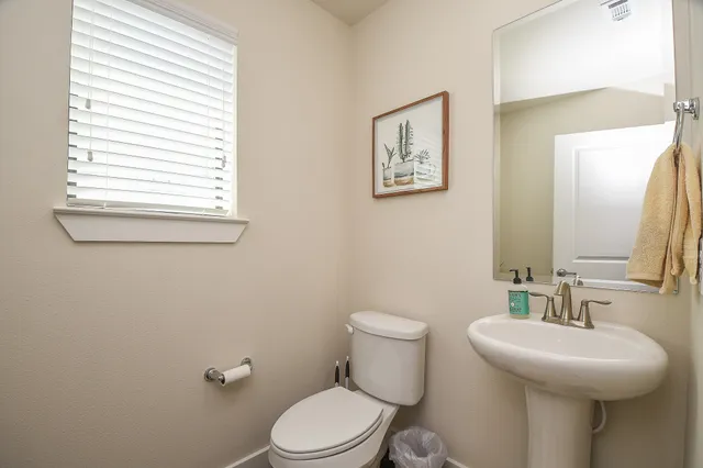 a bathroom with a toilet a sink and a window