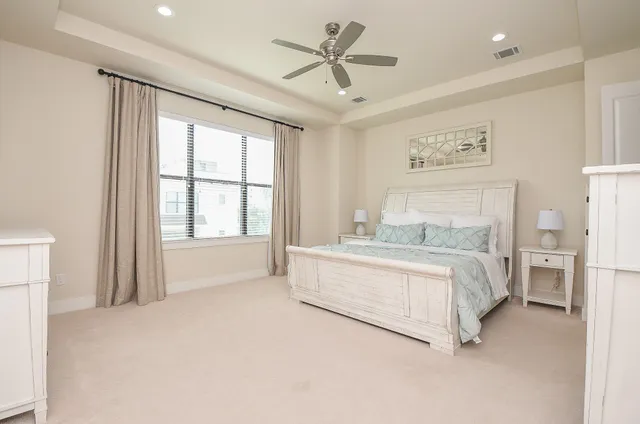 a spacious bedroom with a large bed and a chandelier