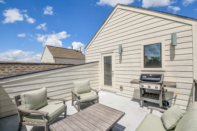 a view of a chairs and table in the back yard of the house