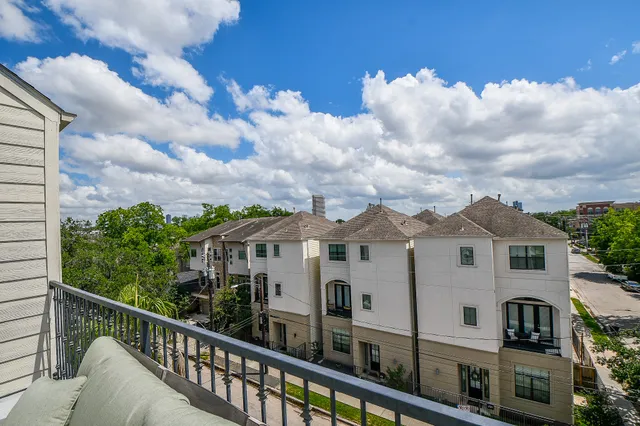 a view of a white house next to a yard