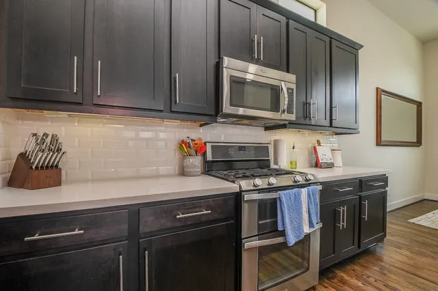 a kitchen with stainless steel appliances granite countertop a stove microwave and cabinets