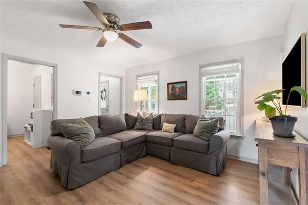 a living room with furniture ceiling fan and a window