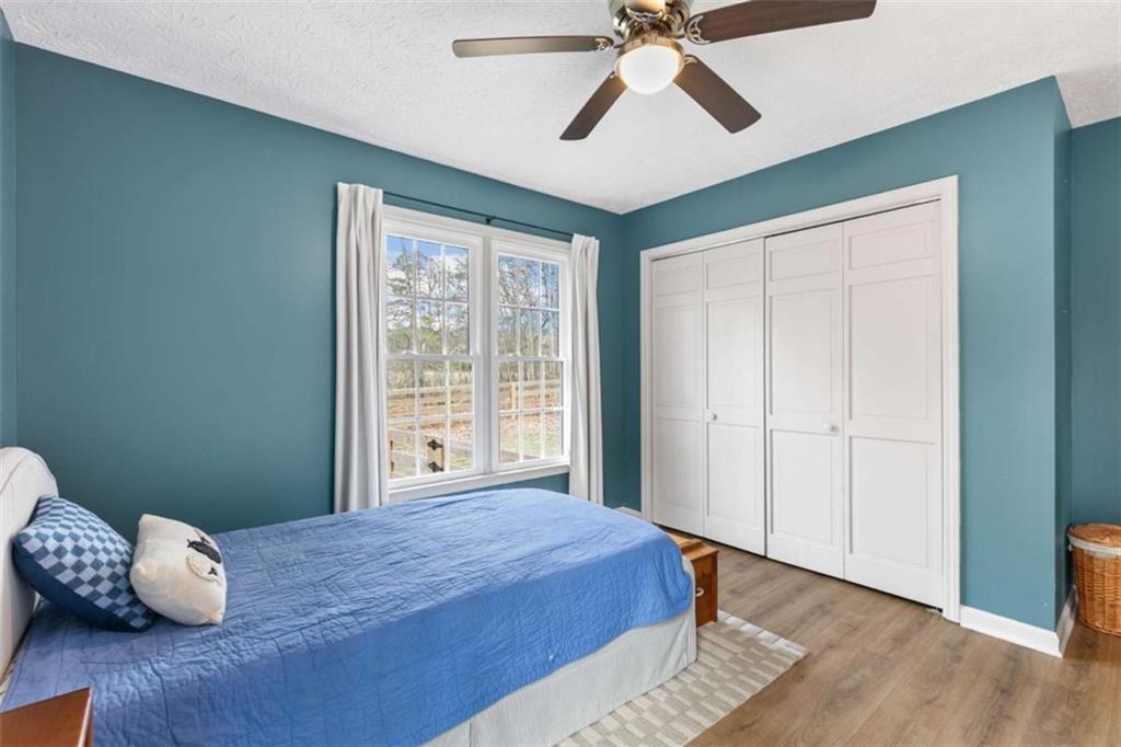 138 Adams Road Fayetteville, GA 30214 - Photo 19 of 38 a bedroom with a bed and wooden floor