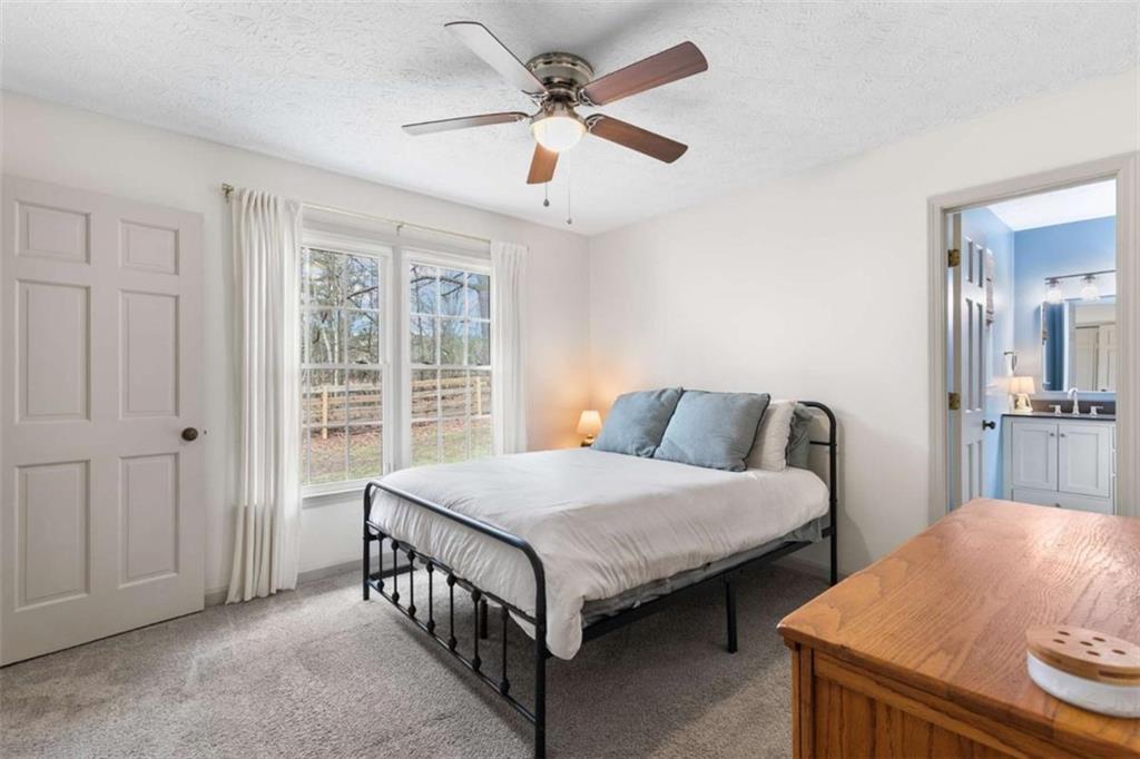 138 Adams Road Fayetteville, GA 30214 - Photo 28 of 38 a bedroom with a bed and a chandelier