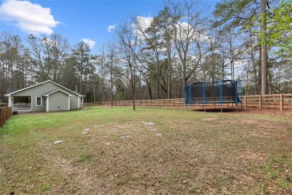 a view of a house with backyard and trees