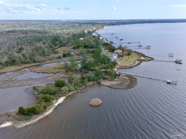 an aerial view of a house with a yard wooden table and chairs