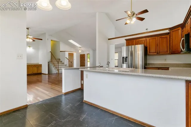 a view of kitchen with sink and refrigerator