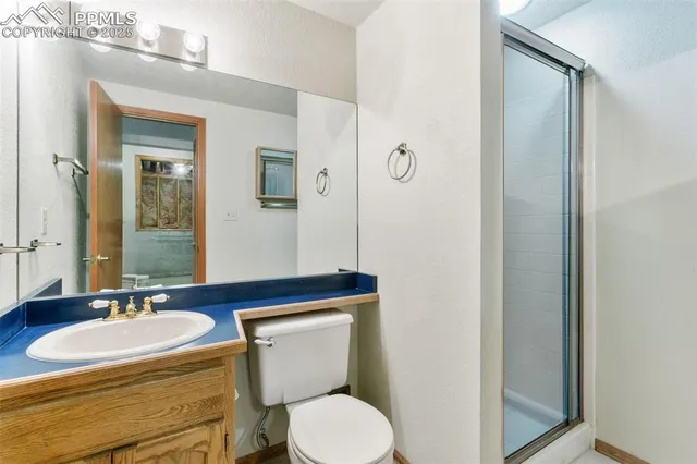 a bathroom with a granite countertop toilet sink and mirror