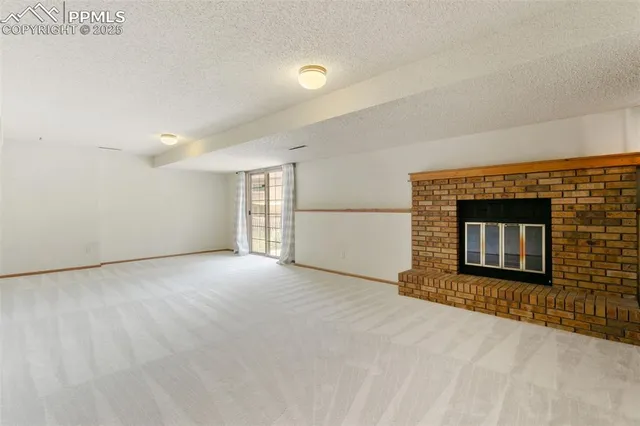 a view of an empty room with a fireplace and a window