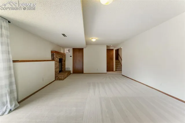 a view of empty room with a kitchen