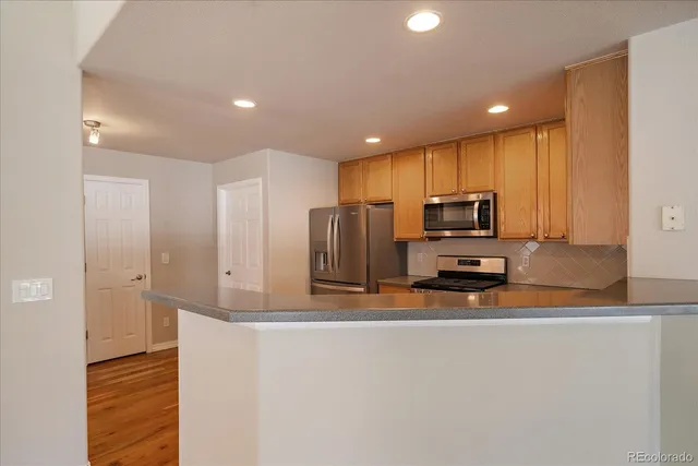 a kitchen with stainless steel appliances a refrigerator and a stove top oven