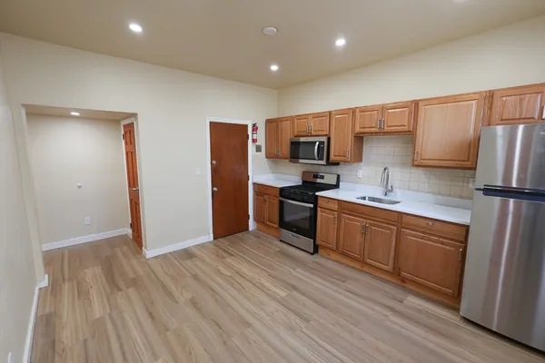 a kitchen with stainless steel appliances a refrigerator sink and microwave