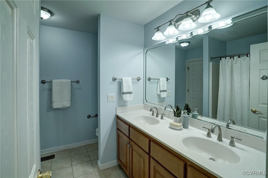 10132 Forest Patch Drive Mechanicsville, VA 23116 - Photo 33 of 43 a bathroom with a double vanity sink a large mirror and shower