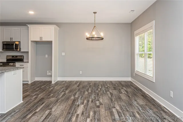 a view of kitchen with granite countertop cabinets and refrigerator
