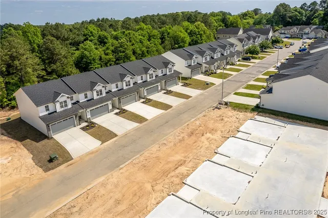 a view of a patio with table and chairs under an umbrella next to a yard