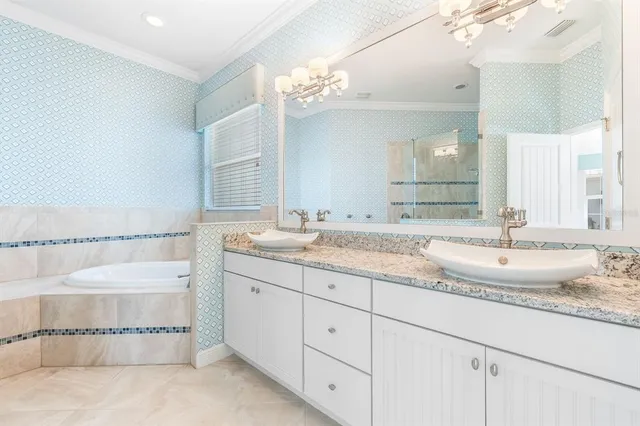 a bathroom with a granite countertop double vanity sink and a mirror