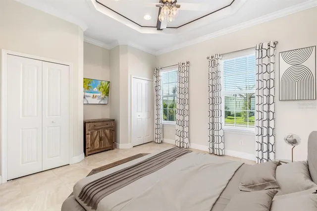 a spacious bedroom with a bed a window and a chandelier