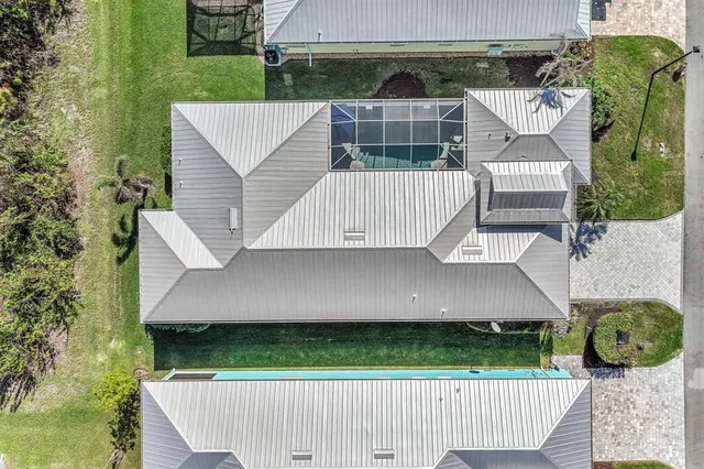 an aerial view of a house with garden space and car parked