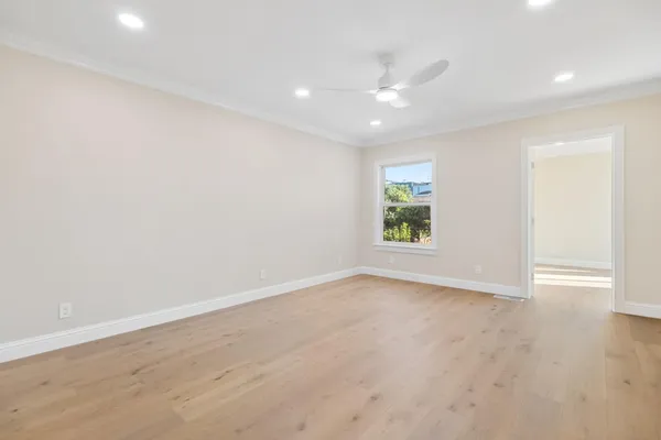 an empty room with window and wooden floor