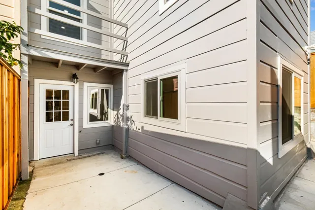 a view of white house with large windows and refrigerator