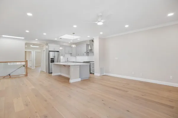 a view of a kitchen with kitchen island a sink stainless steel appliances and cabinets