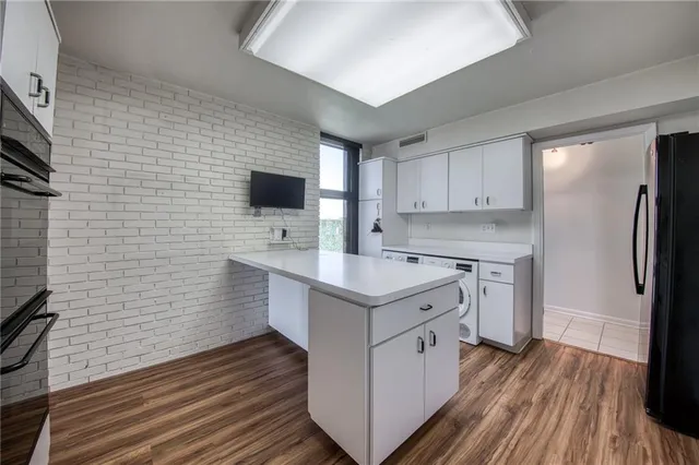 a kitchen with a sink a microwave a stove and cabinets