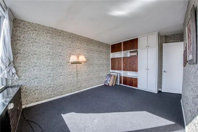 a spacious bedroom with a bed and a cabinets