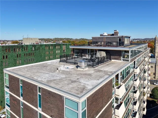 a roof deck with table and chairs a barbeque