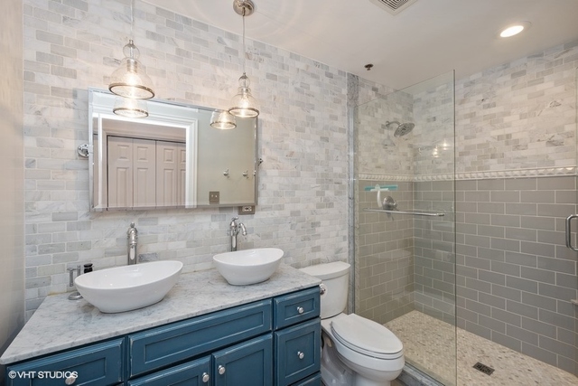 1016 West Madison Street, Unit 3S Chicago, IL 60607 - Photo 16 of 22 a bathroom with a granite countertop sink a toilet and a mirror