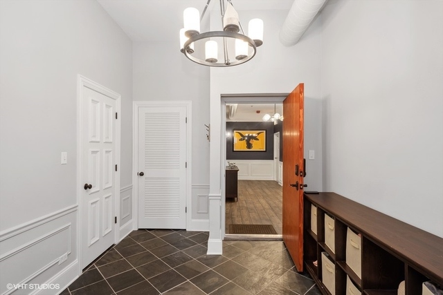 1016 West Madison Street, Unit 3S Chicago, IL 60607 - Photo 4 of 22 a view of a hallway with wooden floor and staircase