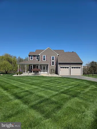 a view of a big house with a big yard and large trees