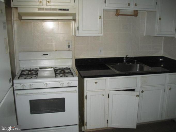 3510 Edwin Street Silver Spring, MD 20902 - Photo 2 of 8 a kitchen with granite countertop white cabinets and white stove