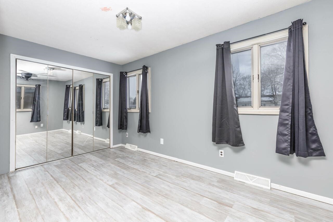 7401 Randy Road Machesney Park, IL 61115 - Photo 14 of 27 a view of an empty room with wooden floor and a bathroom