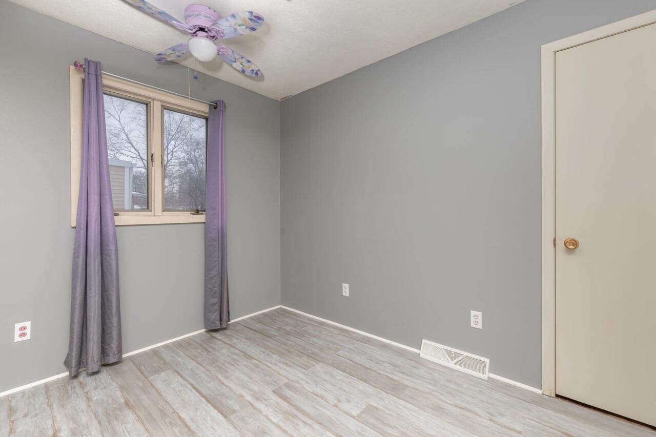 7401 Randy Road Machesney Park, IL 61115 - Photo 17 of 27 a view of an empty room with wooden floor and a window