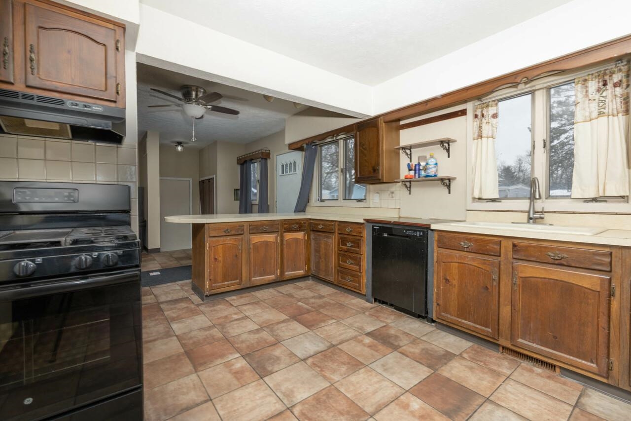 7401 Randy Road Machesney Park, IL 61115 - Photo 8 of 27 a kitchen with stainless steel appliances granite countertop a stove a sink and a microwave