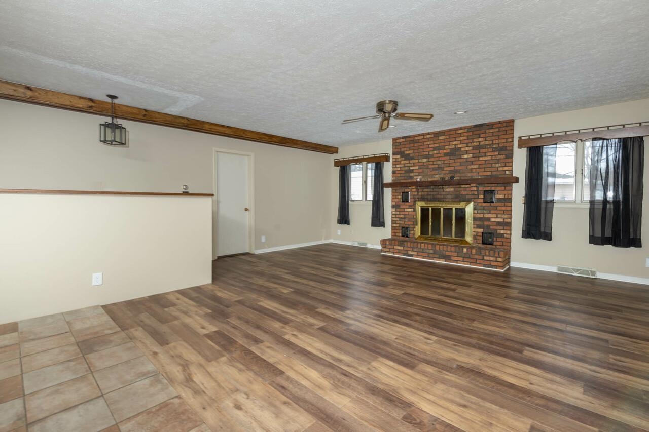 7401 Randy Road Machesney Park, IL 61115 - Photo 10 of 27 a view of empty room with wooden floor and fireplace