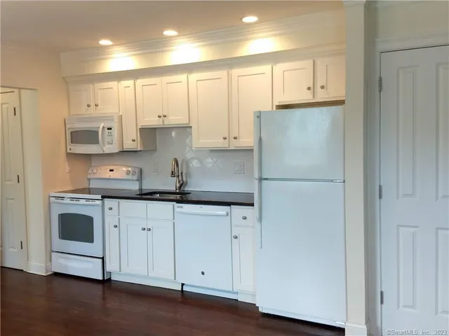 a kitchen with stainless steel appliances granite countertop a refrigerator and a stove top oven