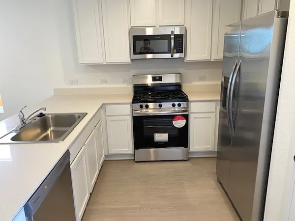 a kitchen with a stove sink and refrigerator
