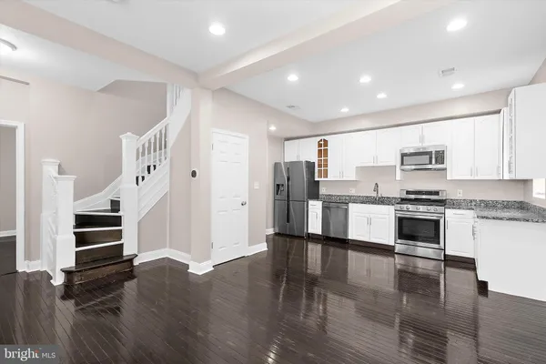 a view of a hallway with wooden floor and stairs