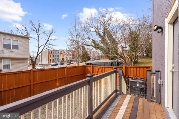 a view of a backyard with a small deck and wooden fence