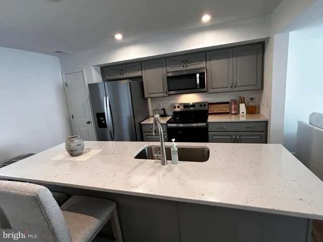 a kitchen with kitchen island a sink appliances and cabinets
