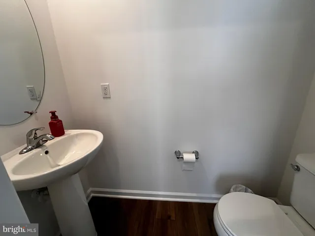 a bathroom with a sink a toilet and mirror