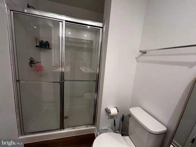 a white toilet sitting next to a shower