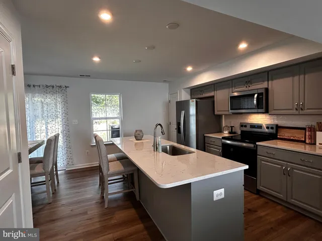 a kitchen that has a lot of cabinets a sink and appliances