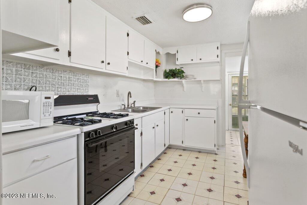 60 Jackson Road Atlantic Beach, FL 32233 - Photo 20 of 42 a kitchen with granite countertop a stove a sink and a refrigerator