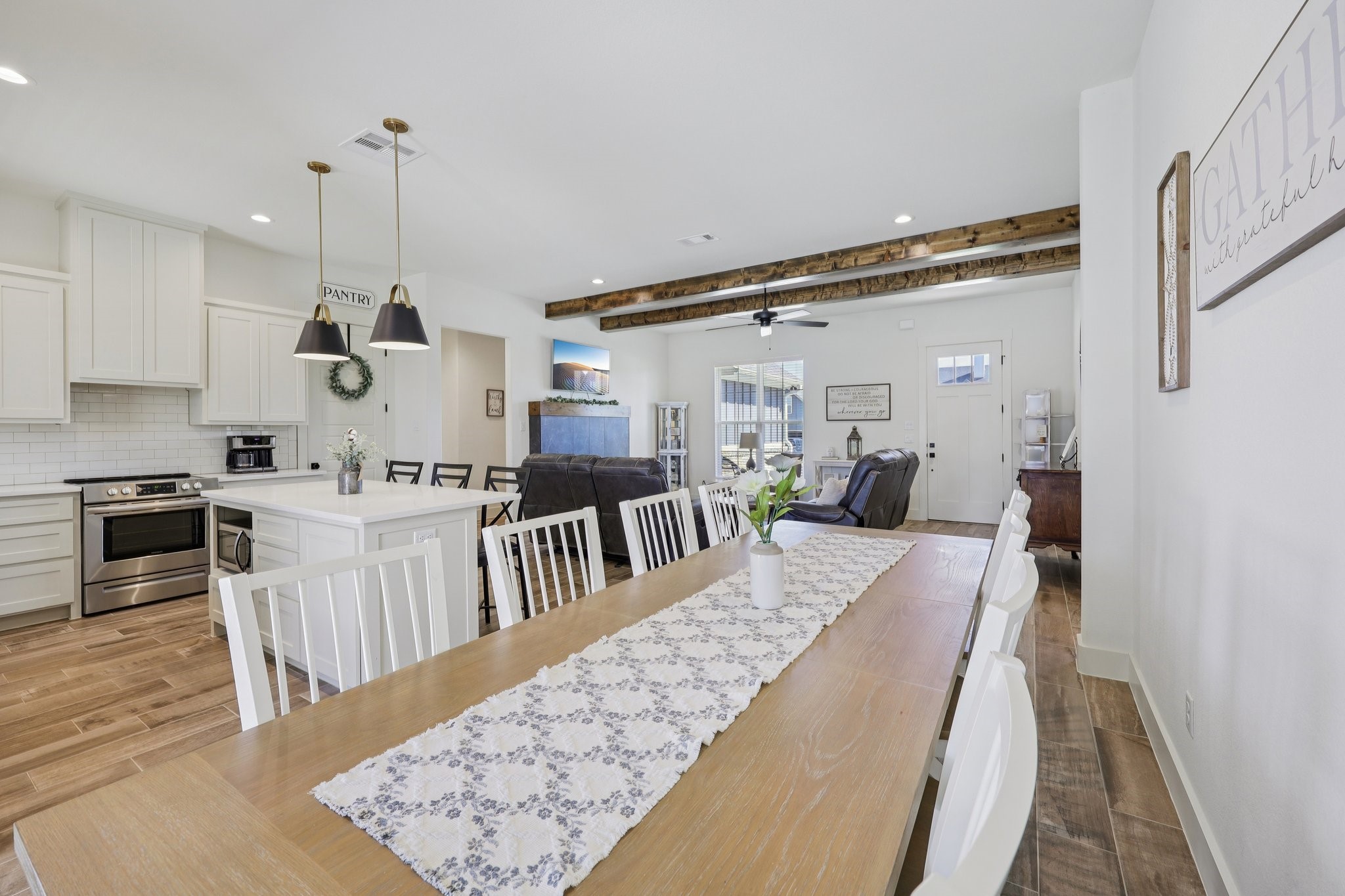 2032 Rattler Way Tolar, TX 76476 - Photo 15 of 49 a large kitchen with kitchen island a stove a sink cabinets and wooden floor