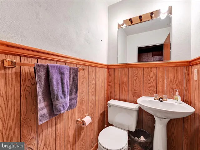 a bathroom with a sink a toilet and mirror