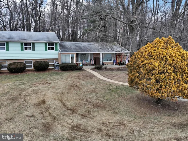 a view of a house with a yard and large tree