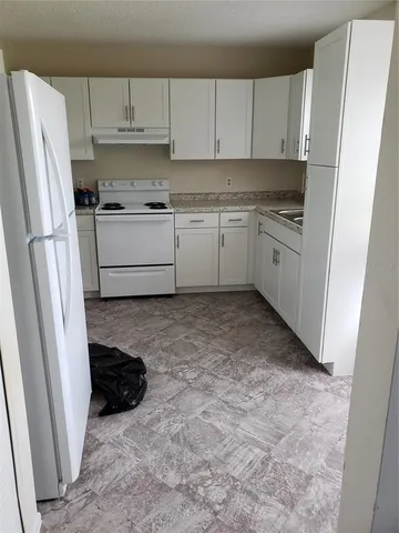 a kitchen with stainless steel appliances a refrigerator sink and cabinets