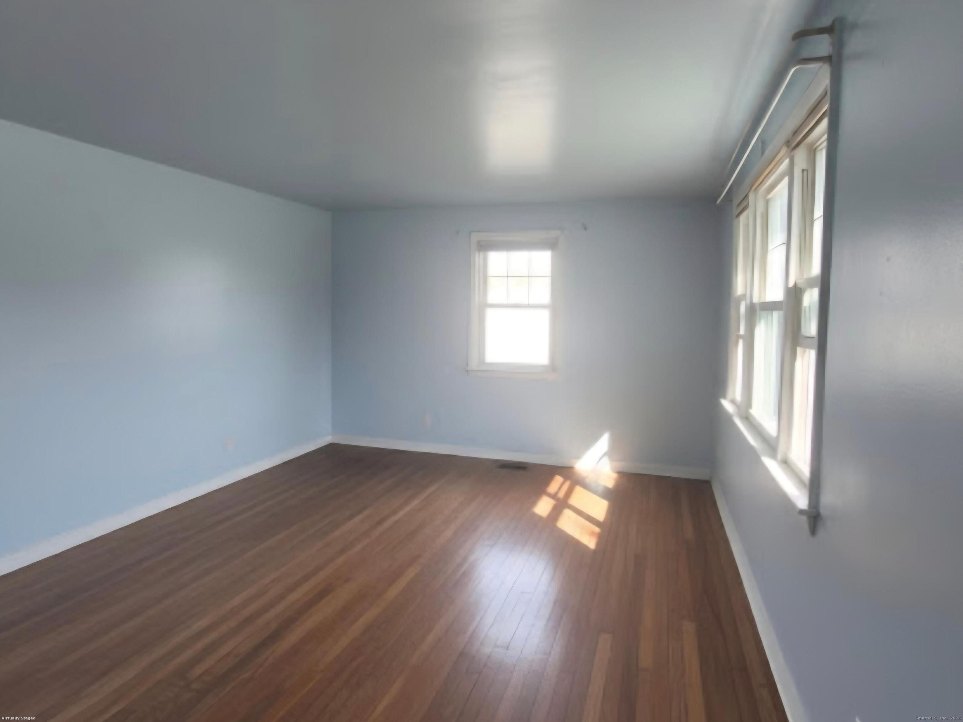 114 Oxford Street Bridgeport, CT 06606 - Photo 2 of 8 an empty room with wooden floor and windows